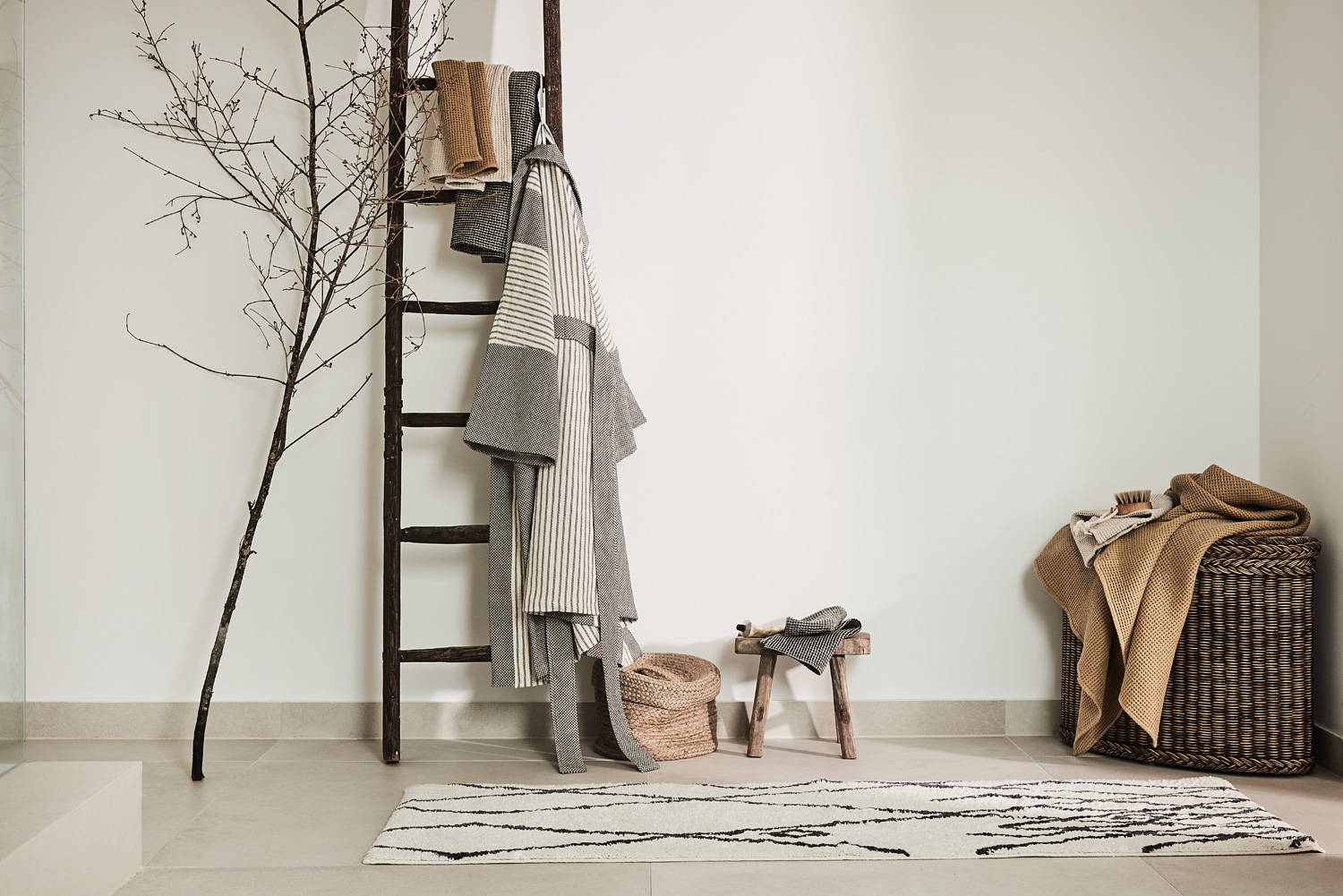 Lagom interior decor with beni rug, ladder, bathrobe, towels and rattan basket