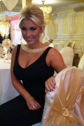 Woman in a black dress sat at a wedding table.