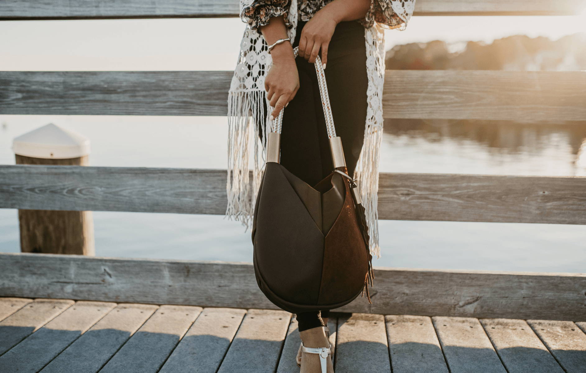 small brown leather tote on the dock at sunset