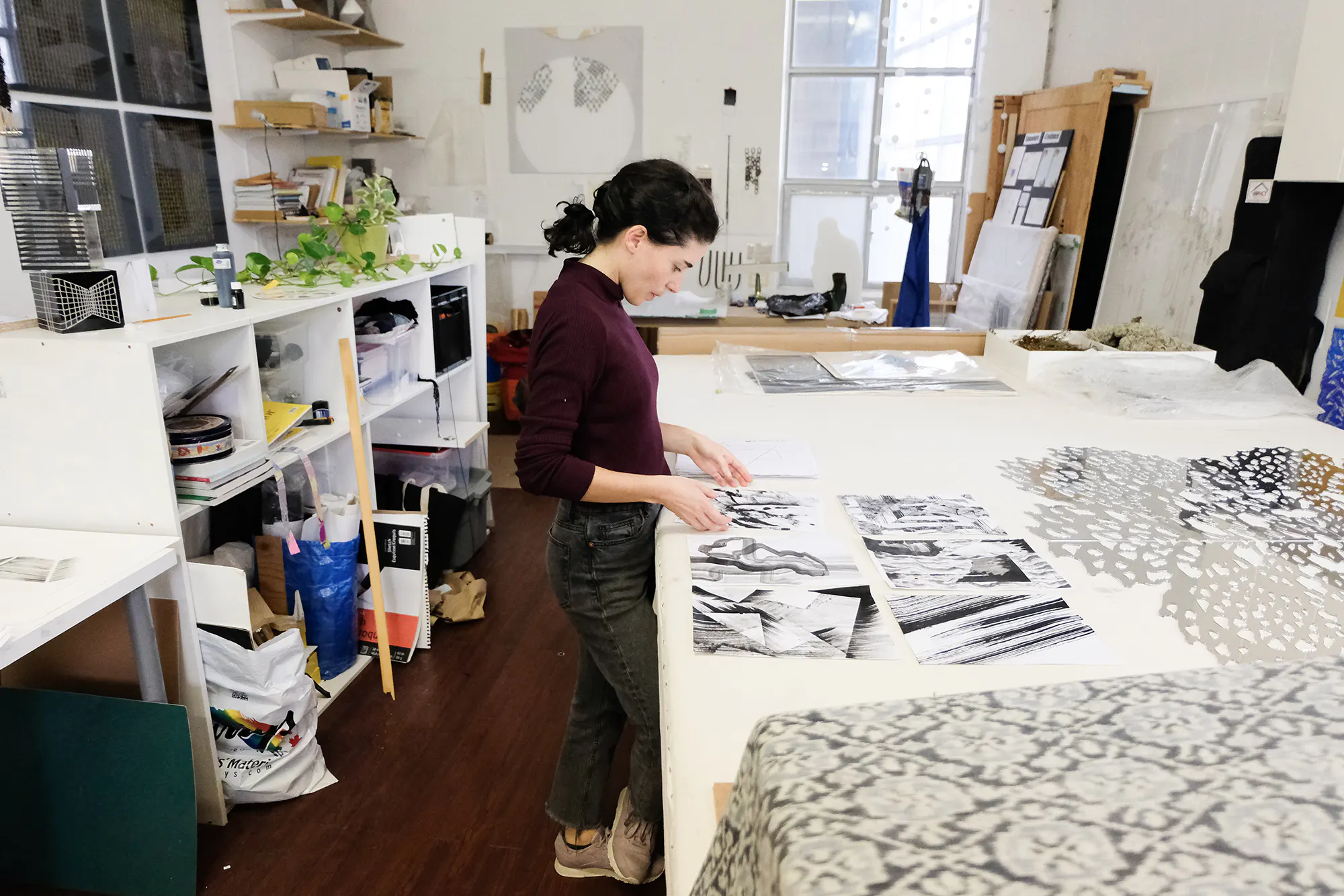 Sofia stands at her workbench in her studio.