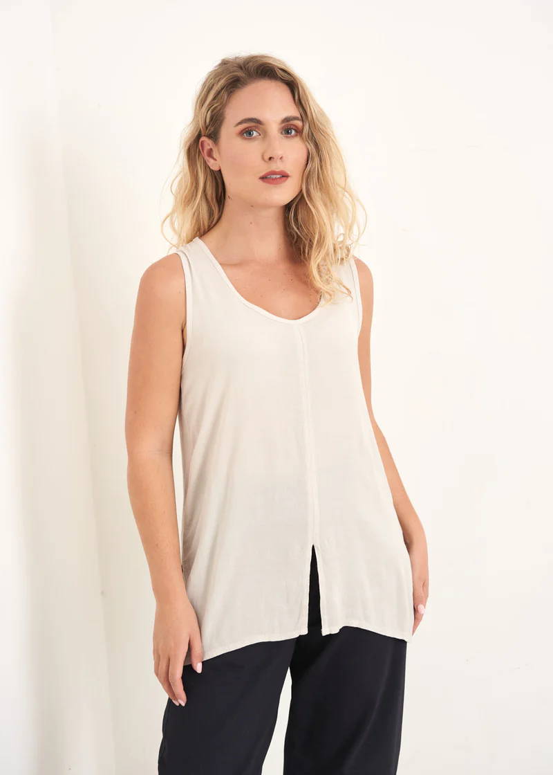 A model wearing an off white sleeveless top