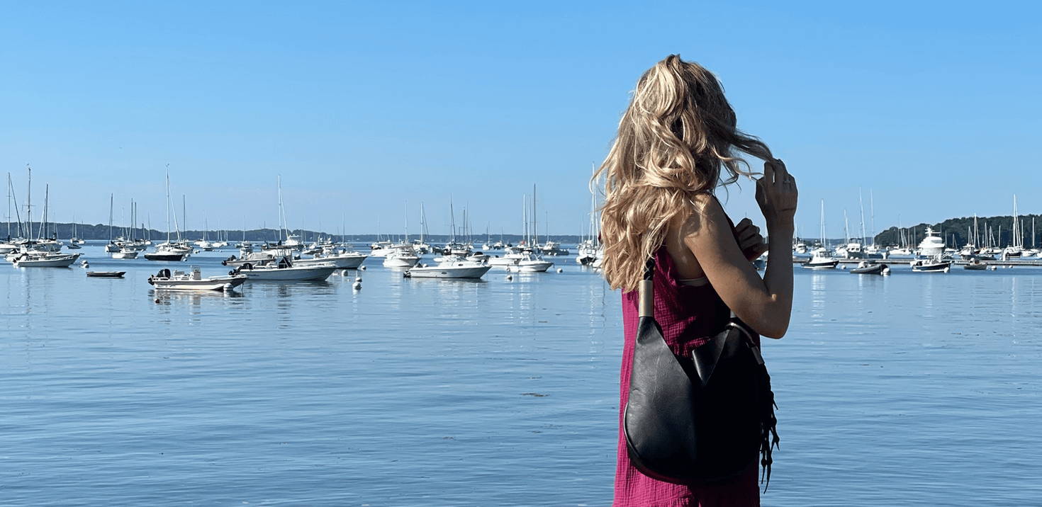 woman wearing a black leather bag on the harbor