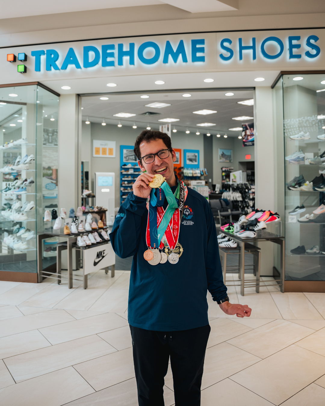 Person holding medals in front of a shoe store.
