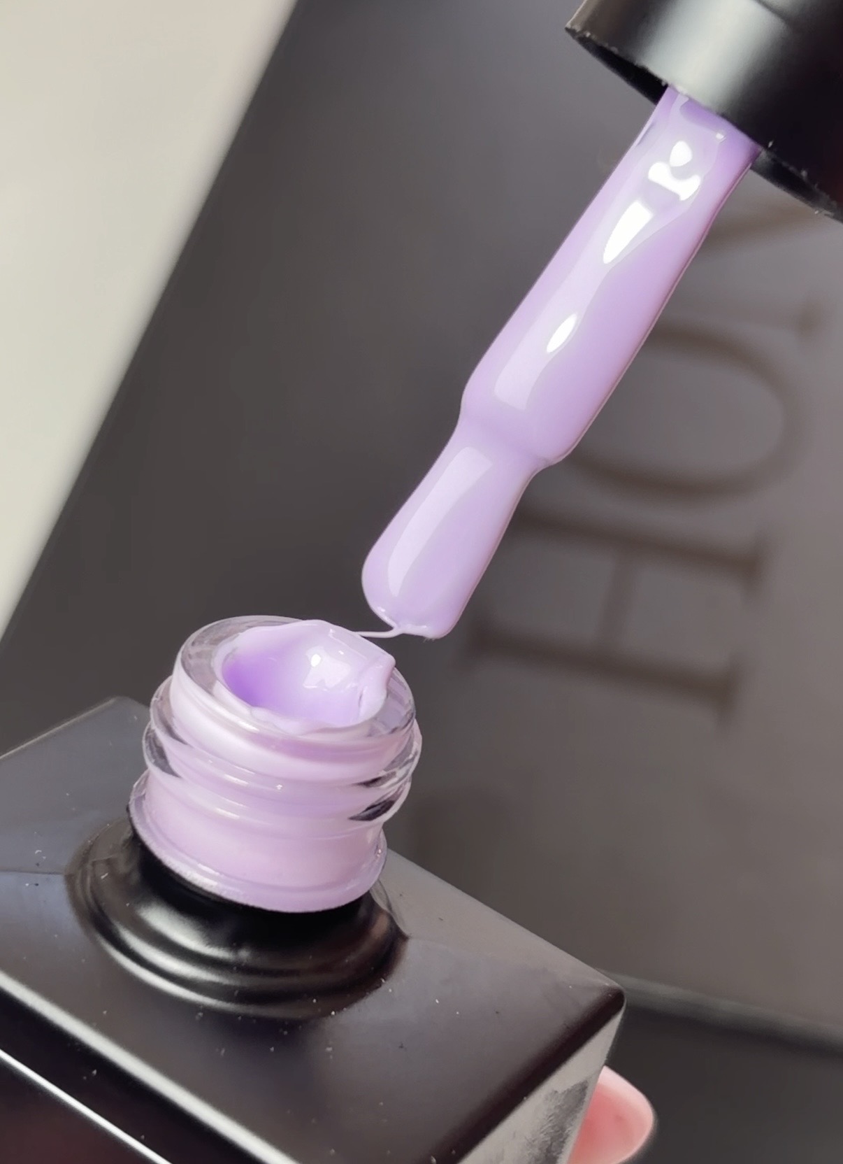 Purple nail polish being poured from a bottle.