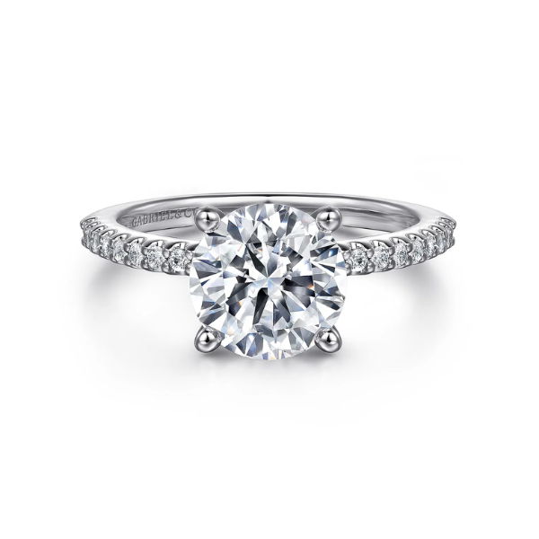A diamond engagement ring with a round center stone and smaller side stones.