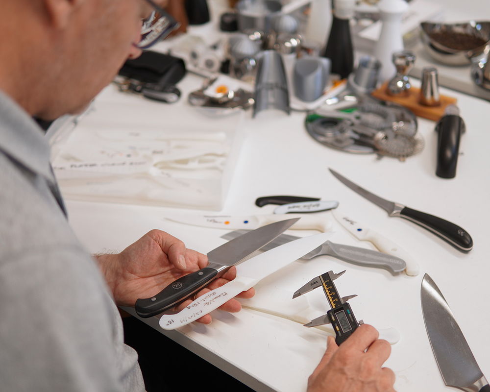 Paul examining knives on a work table.