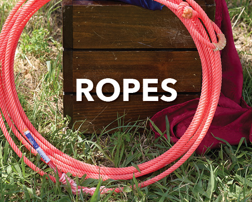 A circular arrangement of pink ropes on grass with a wooden box.