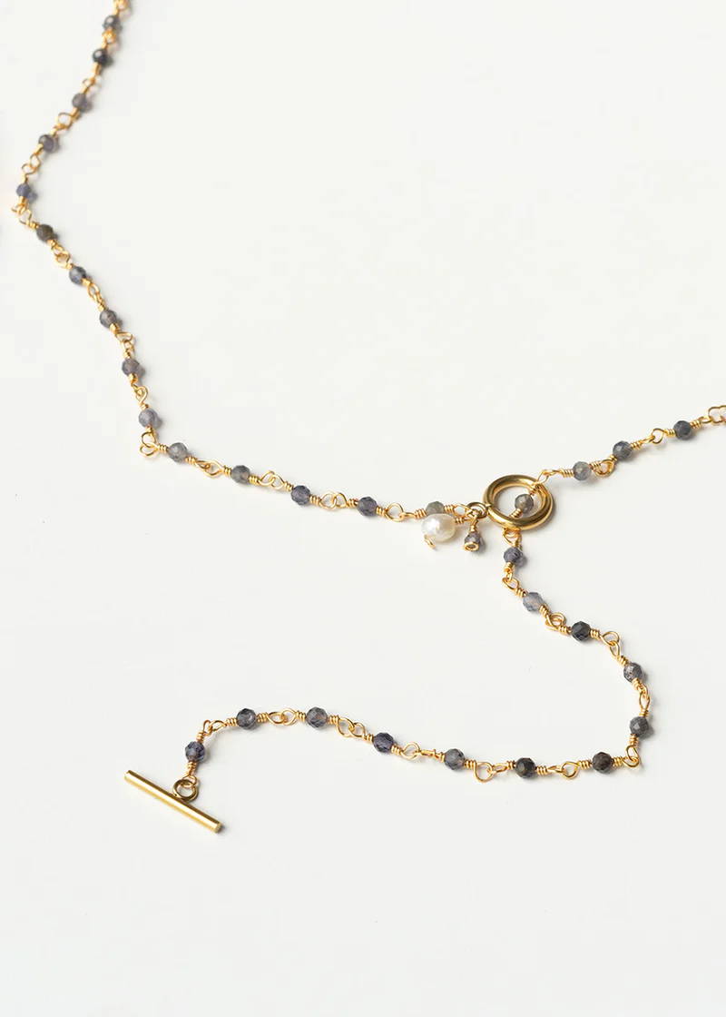 A gold necklace with a t-bar clasp and light grey pyrite beads 