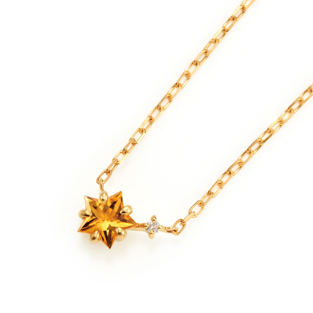 Gold necklace with a star-shaped yellow gemstone and small diamond accent.