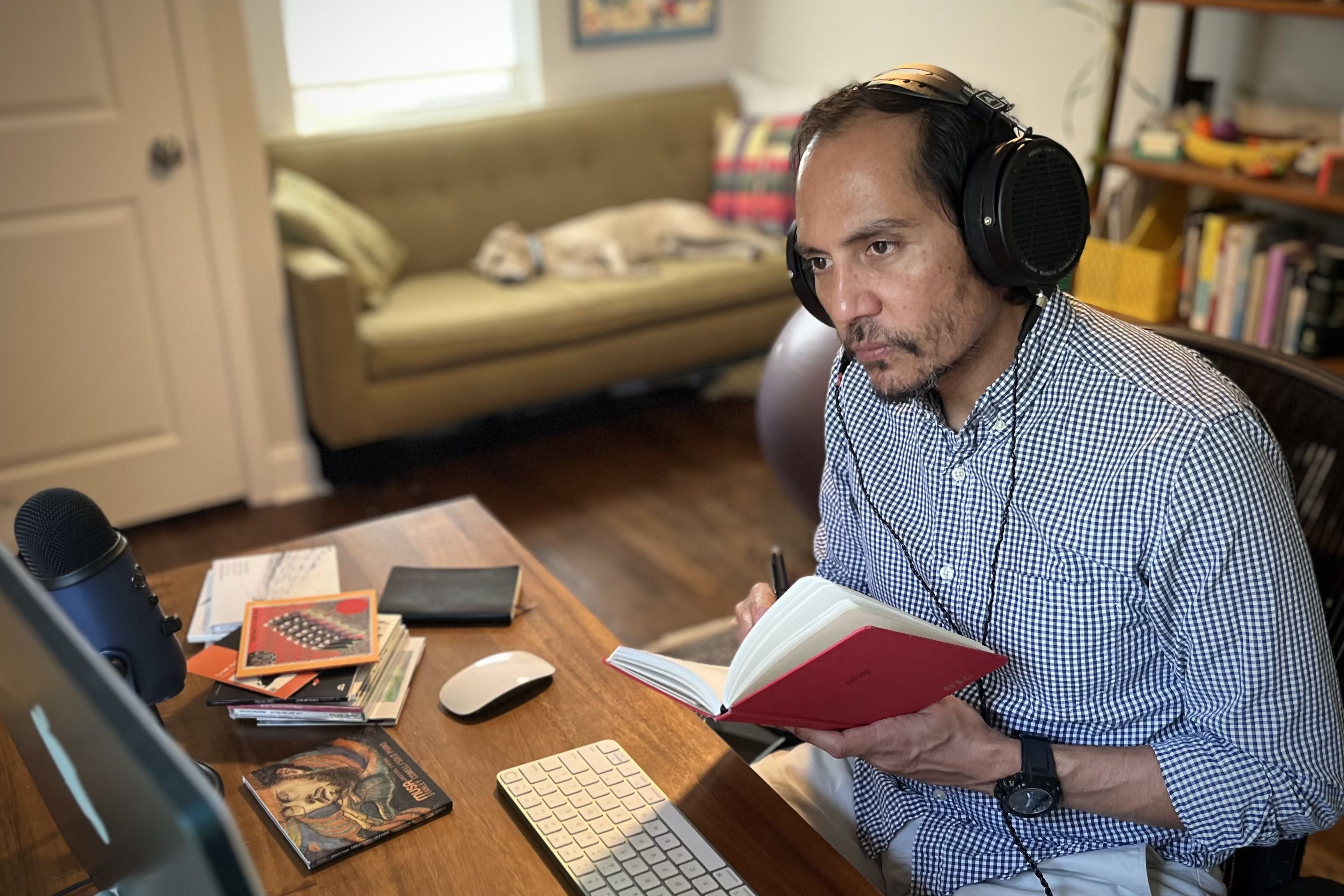 Nate Chinen wearing Audeze LCD-X headphones writing notes