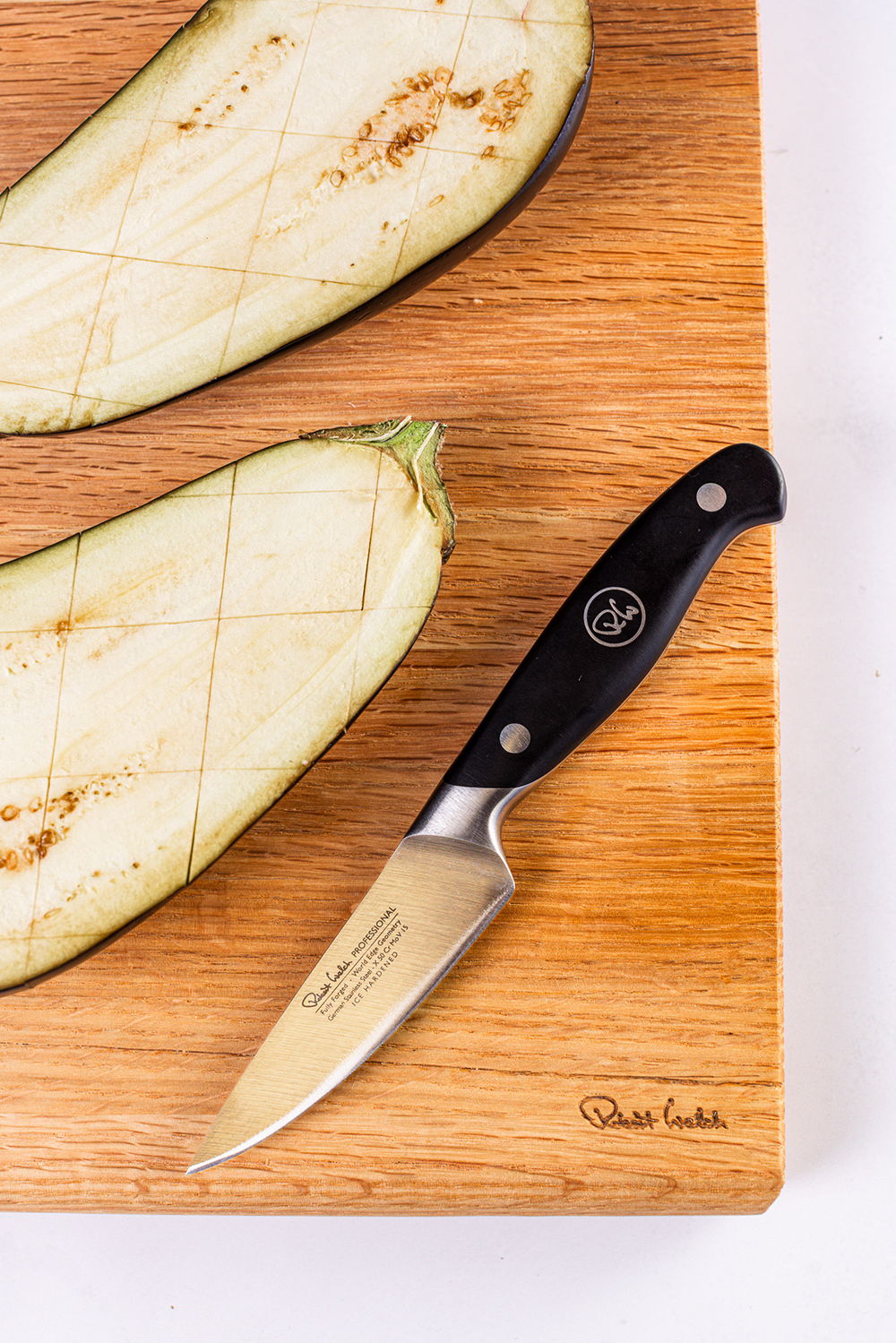 A chopping board with sliced eggplant and a Professional Paring Knife.