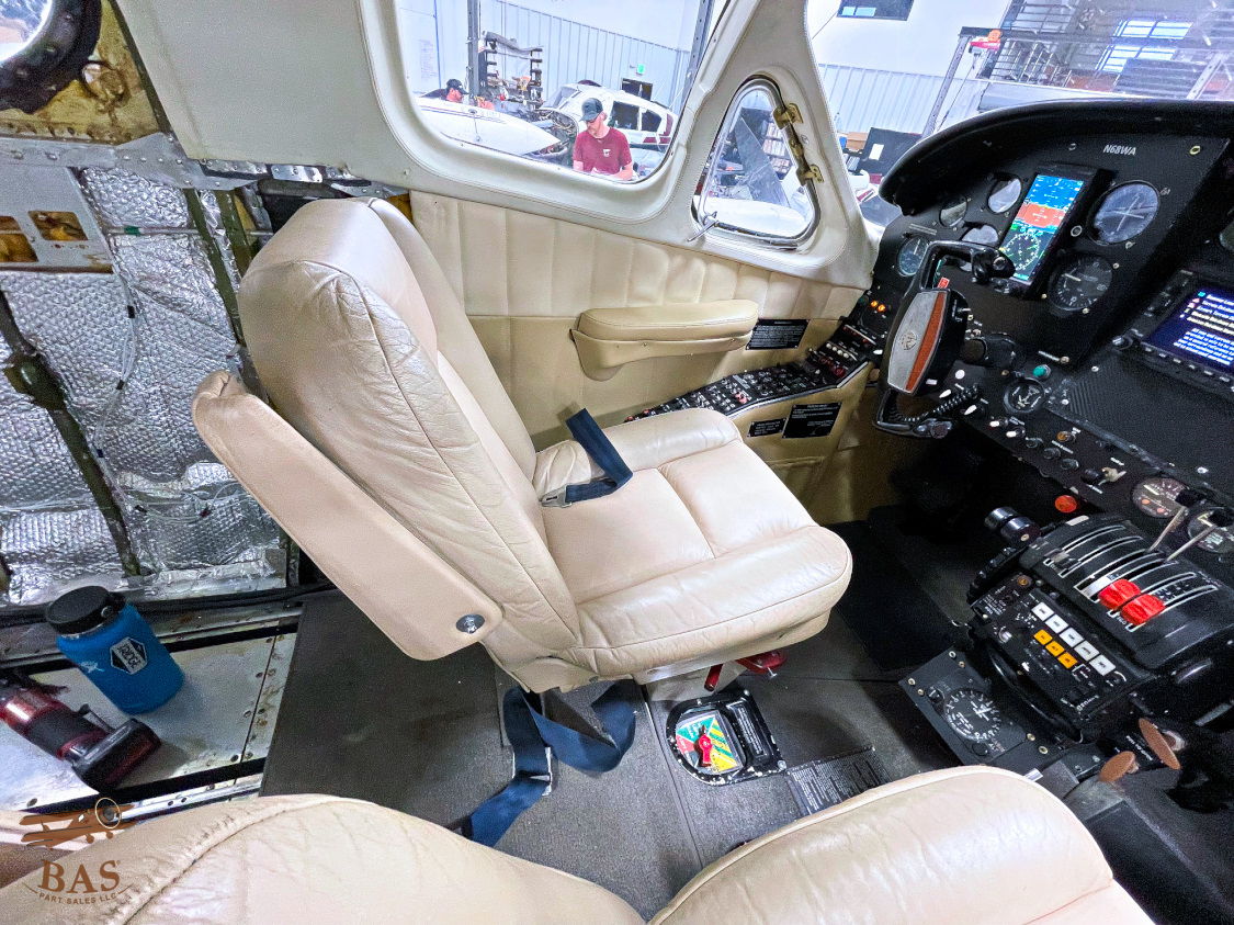 Cockpit interior featuring a beige pilot's seat and control panel.