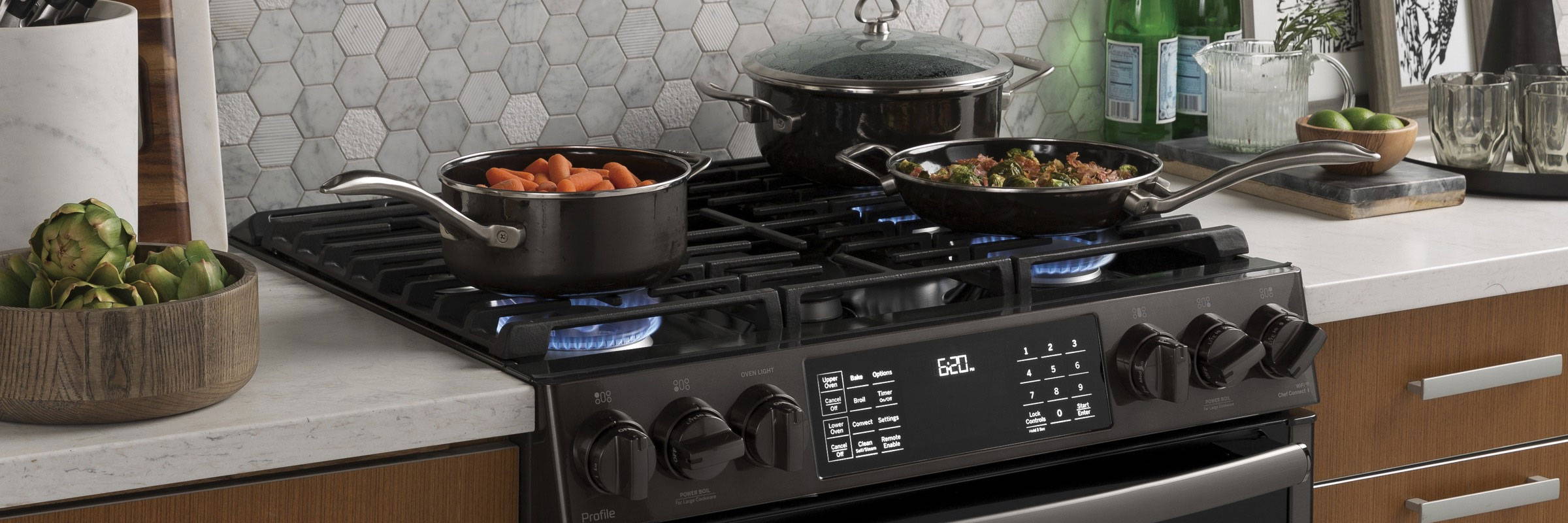 Gas range loaded up with 3 pans of delicious food cooking.