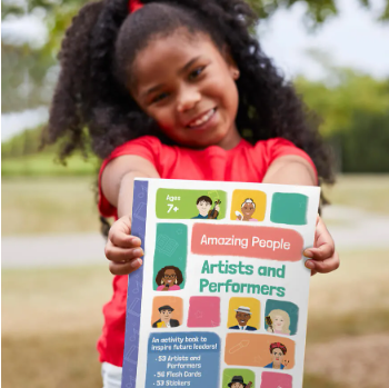 Little girl holding Amazing People Artists and Performers Activity book