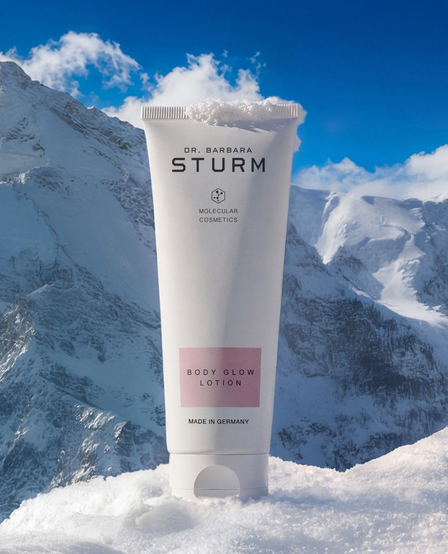 A tube of Dr. Barbara Sturm cream on snowy mountains.