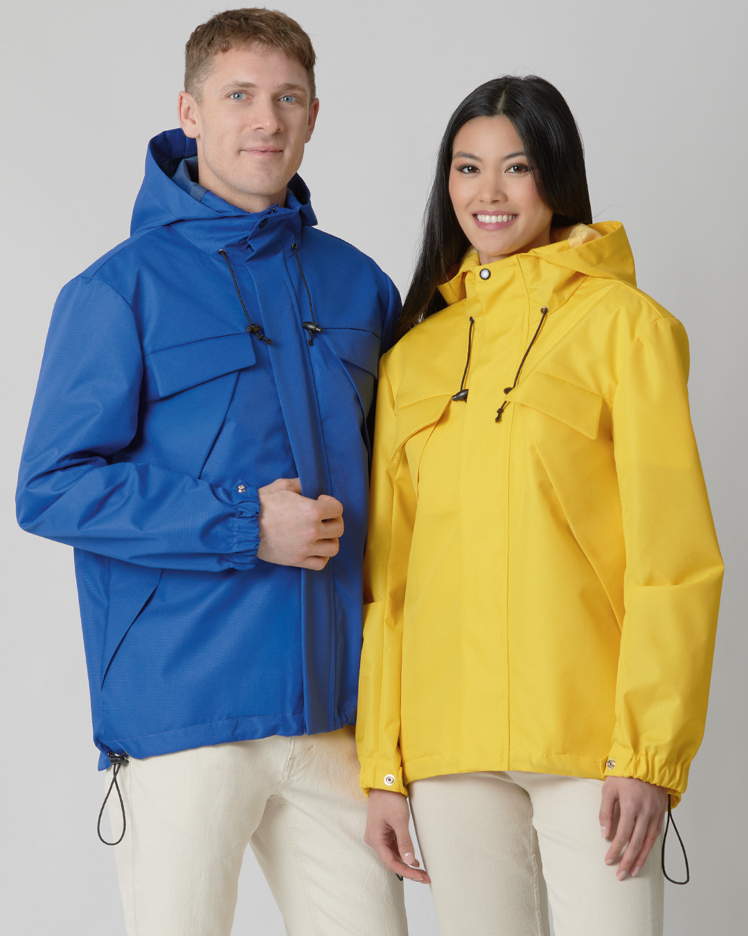 Man in blue jacket and woman in yellow jacket standing together.