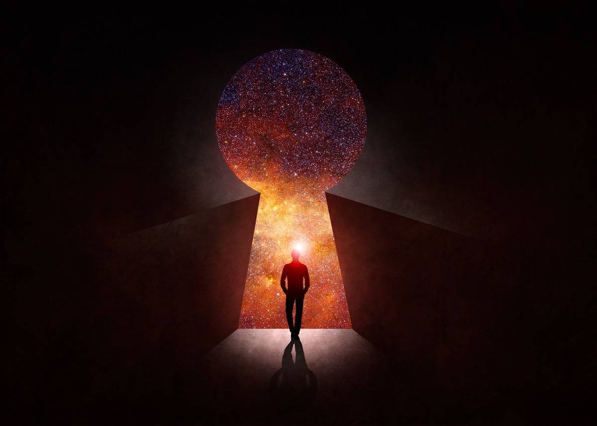 Silhoutte man standing inside a keyhole looking into the universe