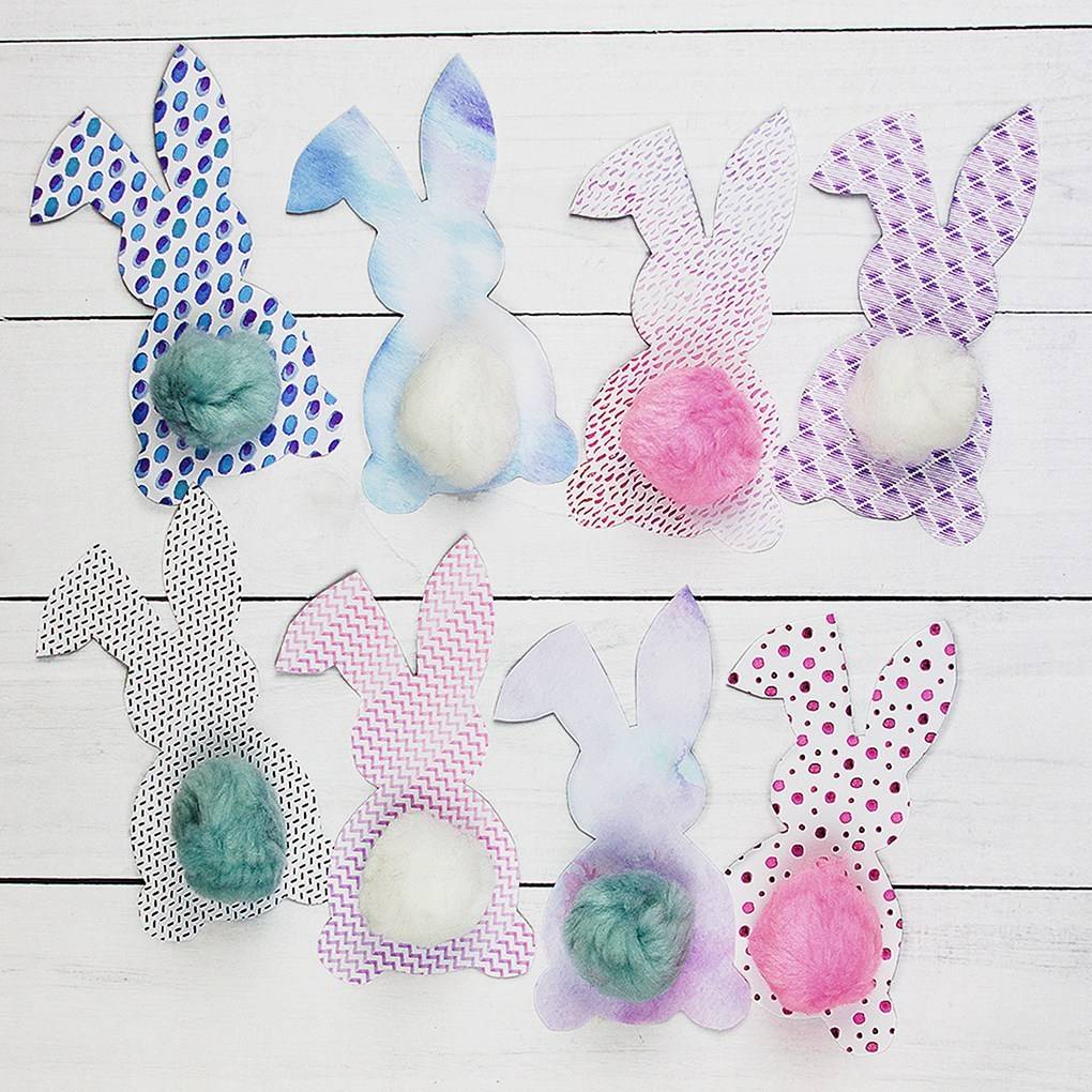 All bunny cut out decorations against a white wooden background.