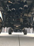 Front undercarriage four black Shocker XL train horn trumpets Rough Country steering stabilizer John's 2014 Dodge Ram 2500 HornBlasters featured customer install gallery photo 2