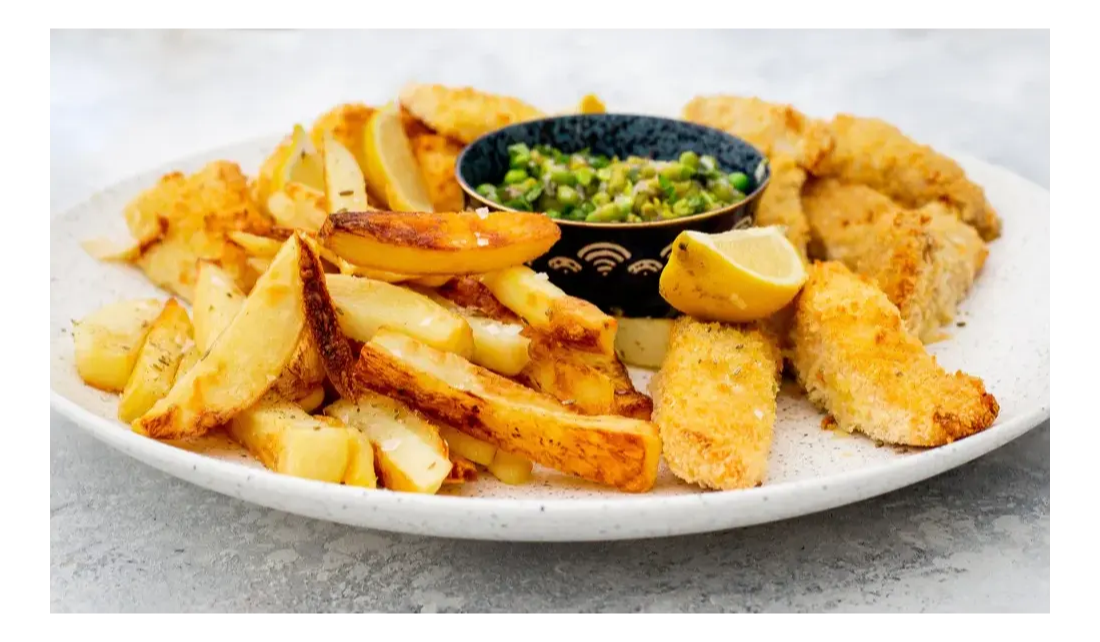A plate of fish, chips and peas.