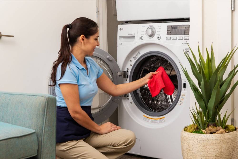 woman placing microfiber towel in washing machine