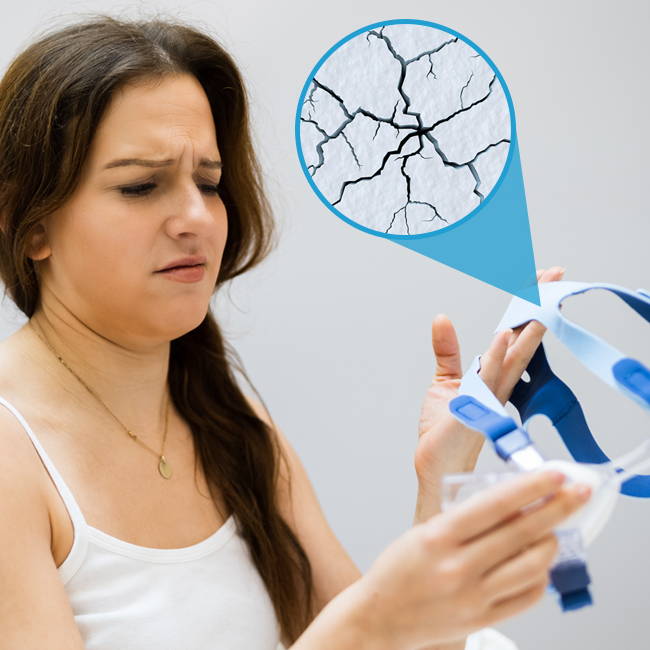 Woman examining a CPAP mask with a graphic showing cracks.