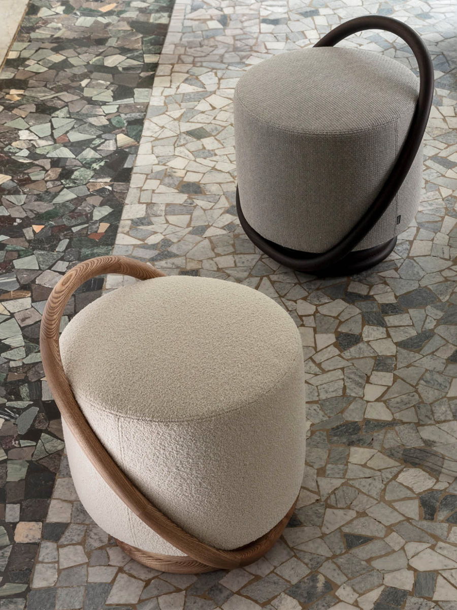 Two modern Porada stools with curved handles on a mosaic floor.