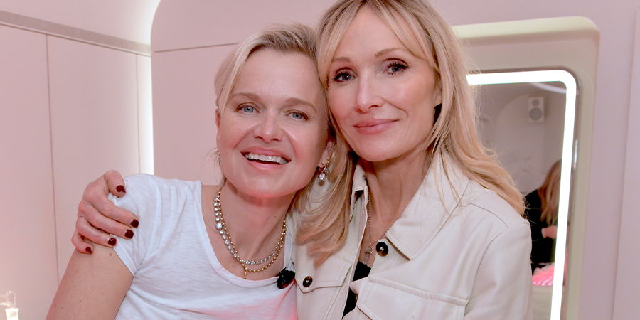 Two women smiling and embracing in a well-lit room.