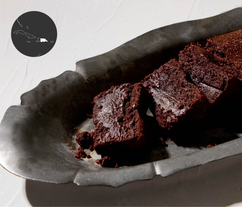 A plate of chocolate brownies on a textured surface.