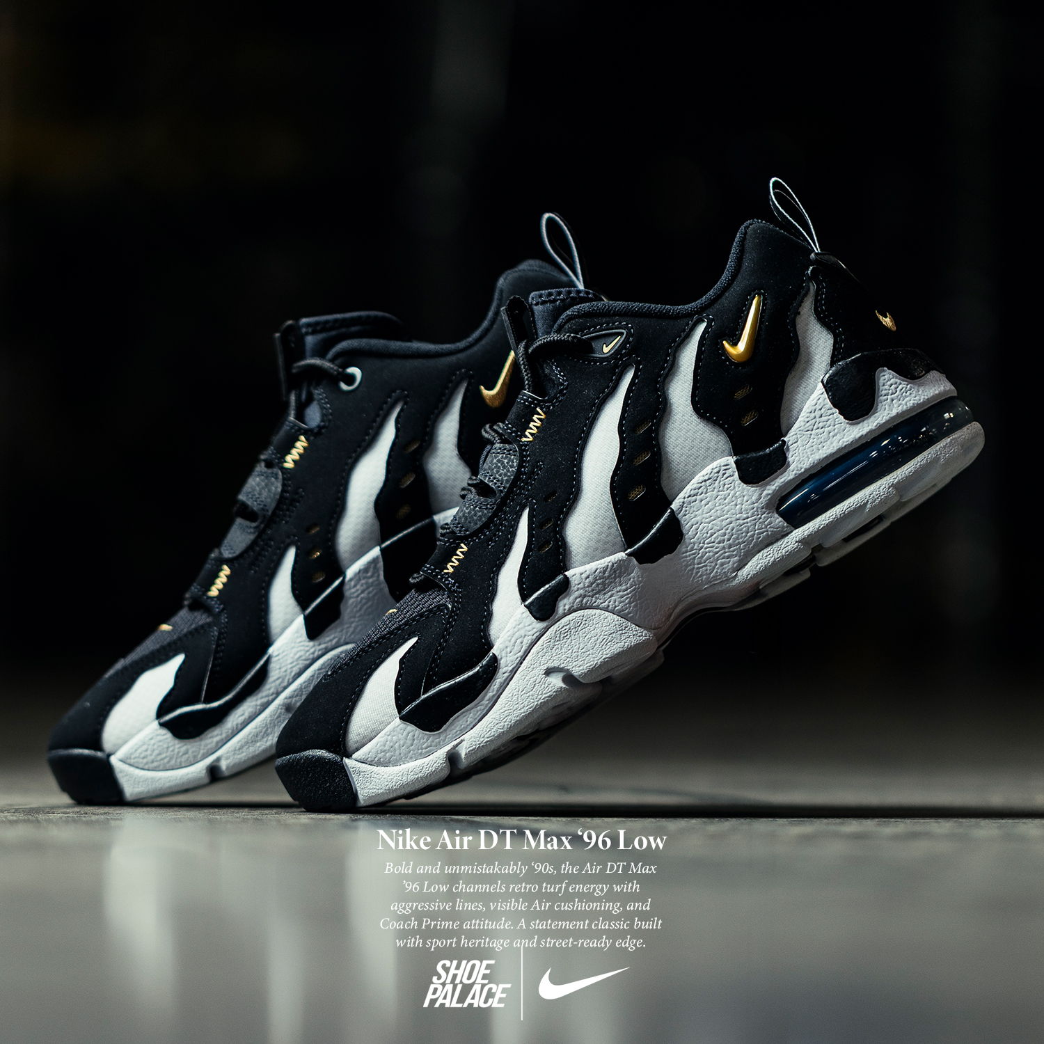 Nike shoes in black and white with yellow accents, displayed on a reflective surface.