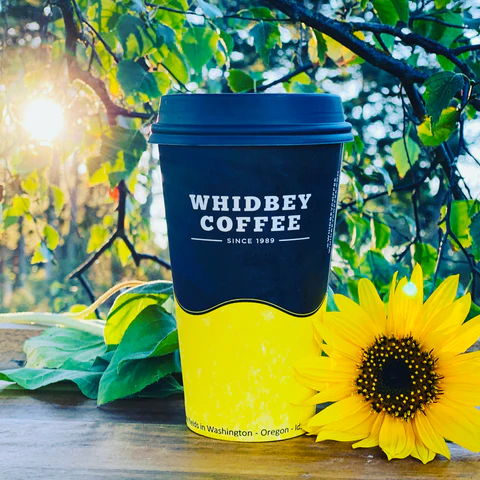 A sunflower next to a cup of coffee