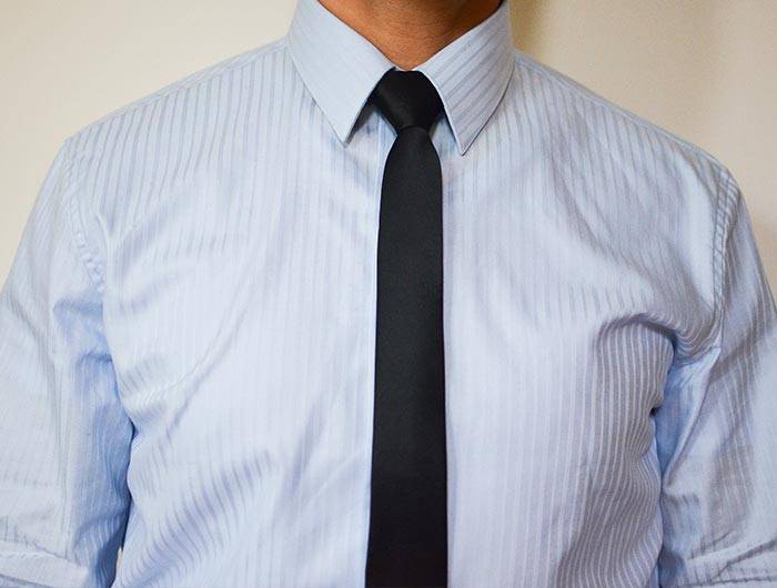 Man wearing a black skinny tie and blue dress shirt