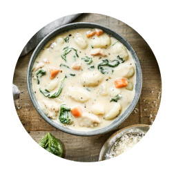 creamy soup with gnocchi, chicken and carrots served in a bowl