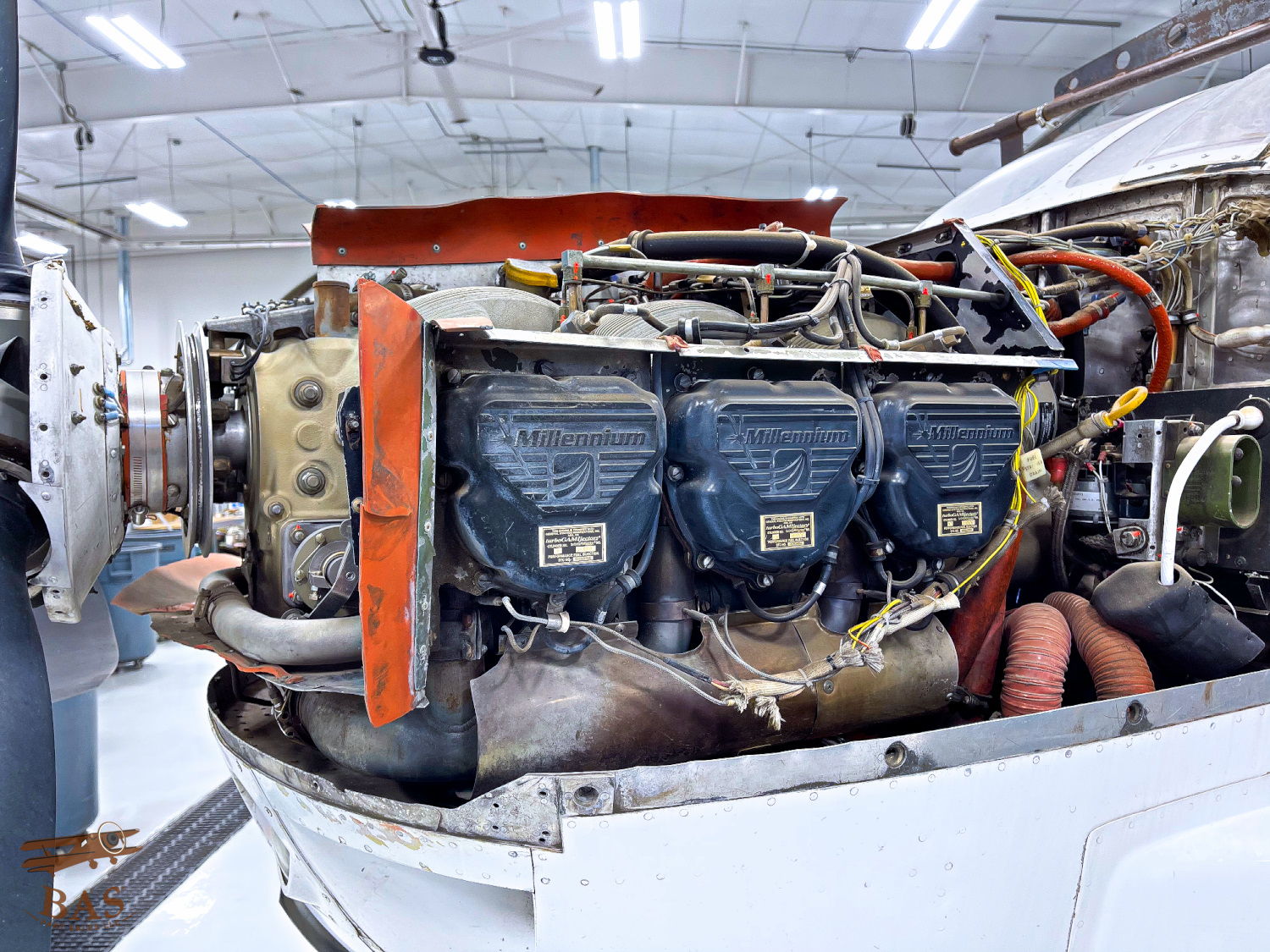 Aircraft engine in a hangar, showing detailed components and wiring.