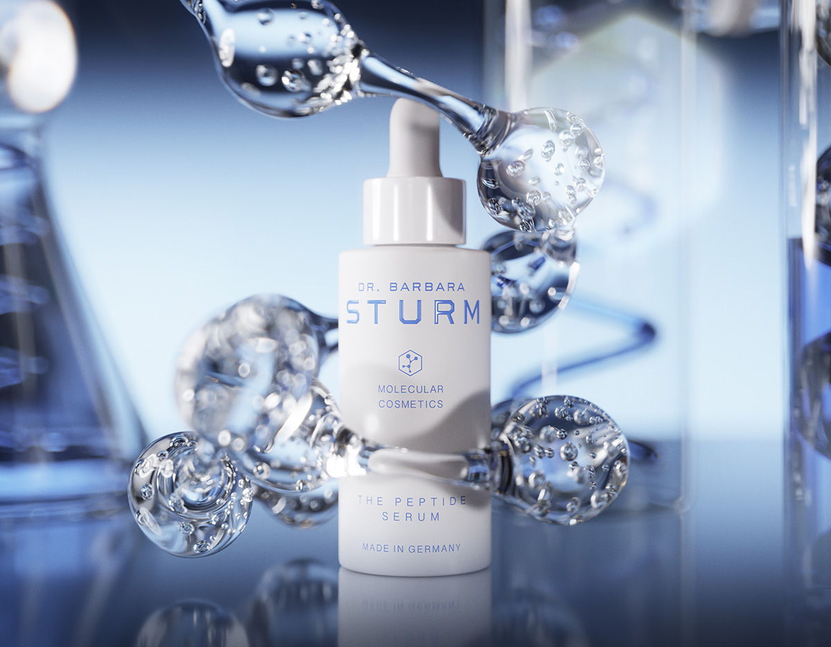 A bottle of skincare serum surrounded by water droplets and blue background.