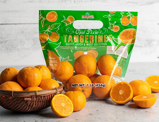 A bag of tangerines with some in a basket and halved.