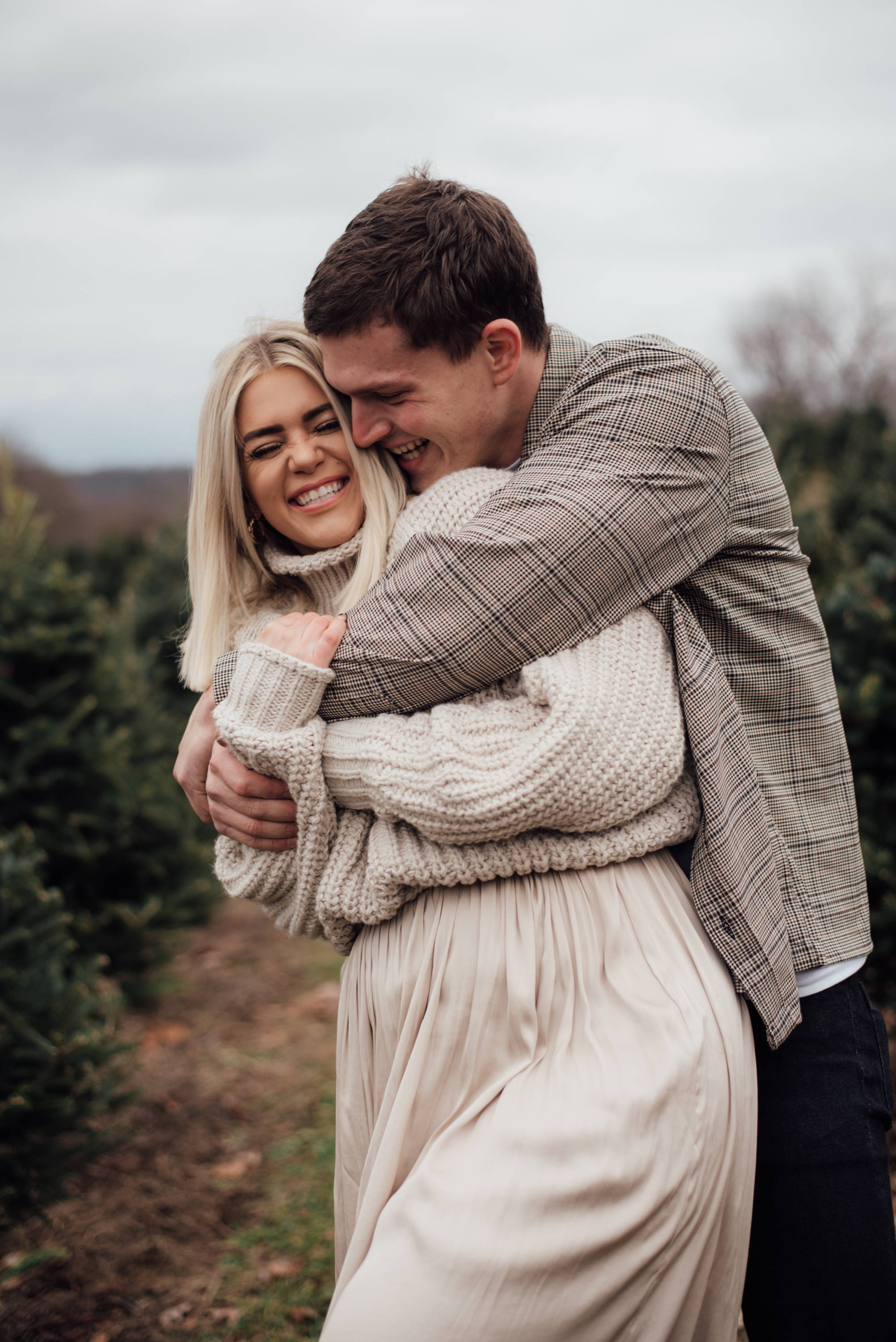 Henne Engagement Ring Couple James & Kelsey Embrace at a Christmas Tree Farm