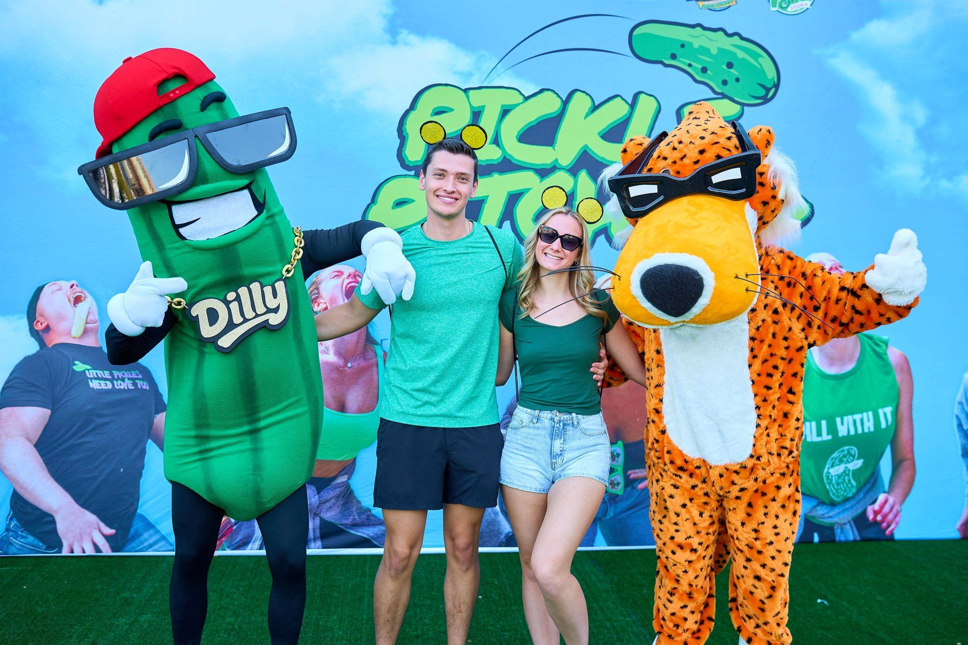 Dilly the Pickle, the trademarked Big Dill mascot, poses with the Cheetos mascot at The Big Dill pickle festival, Globe Life Field and Texas Live!, Arlington Texas 2025.