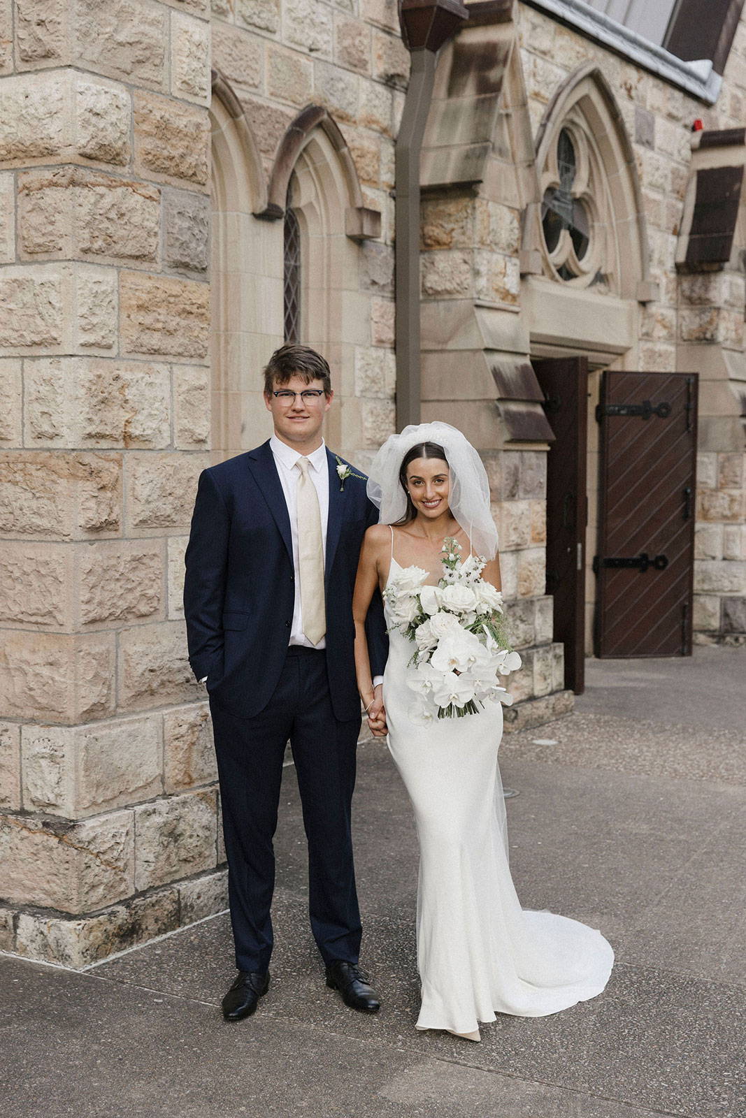 Le marié et la mariée tenant un bouquet