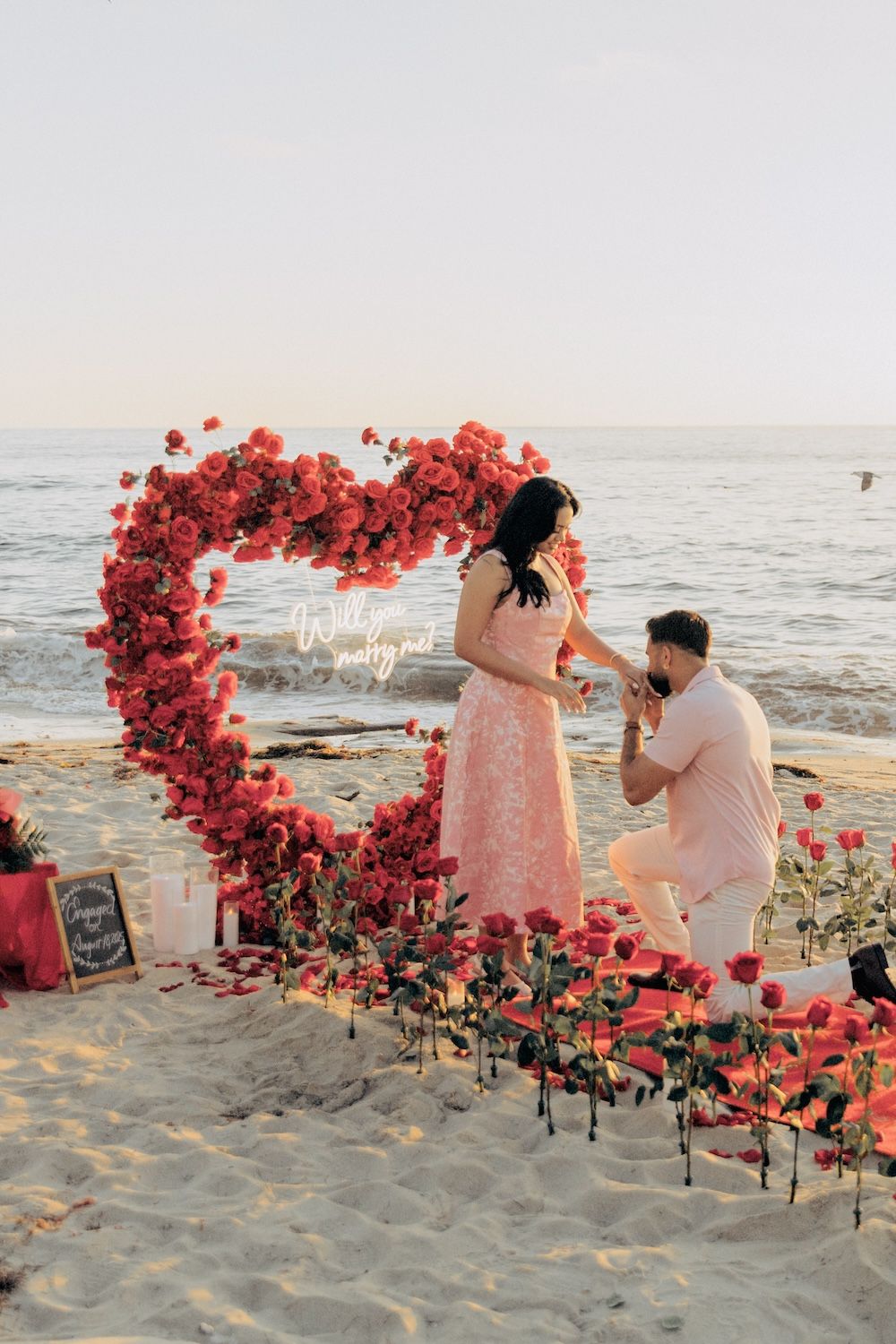 beachfront proposal in front of a heart