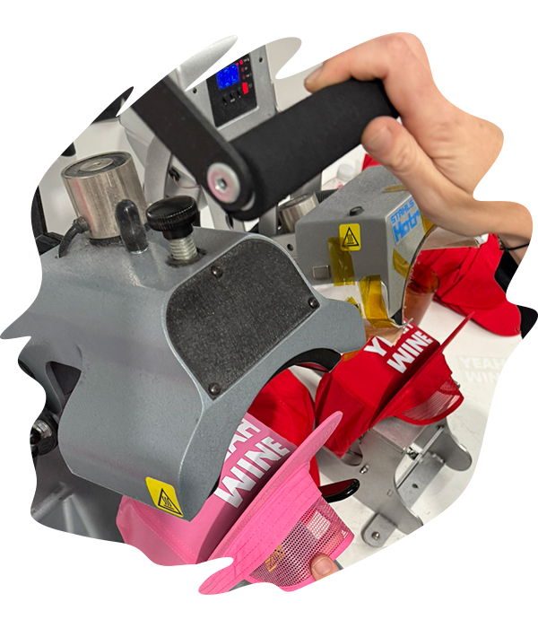 Commercial hat heat press applying heat and pressure onto a pink cap pink with white DTF transfer