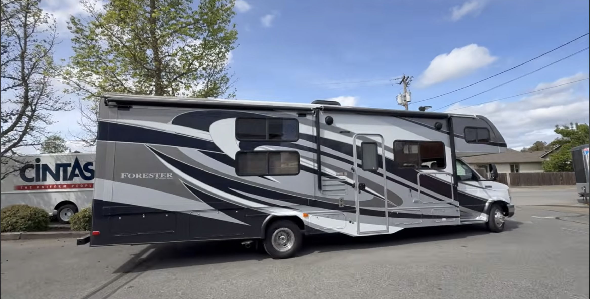 A parked RV with a sleek design against a clear sky.