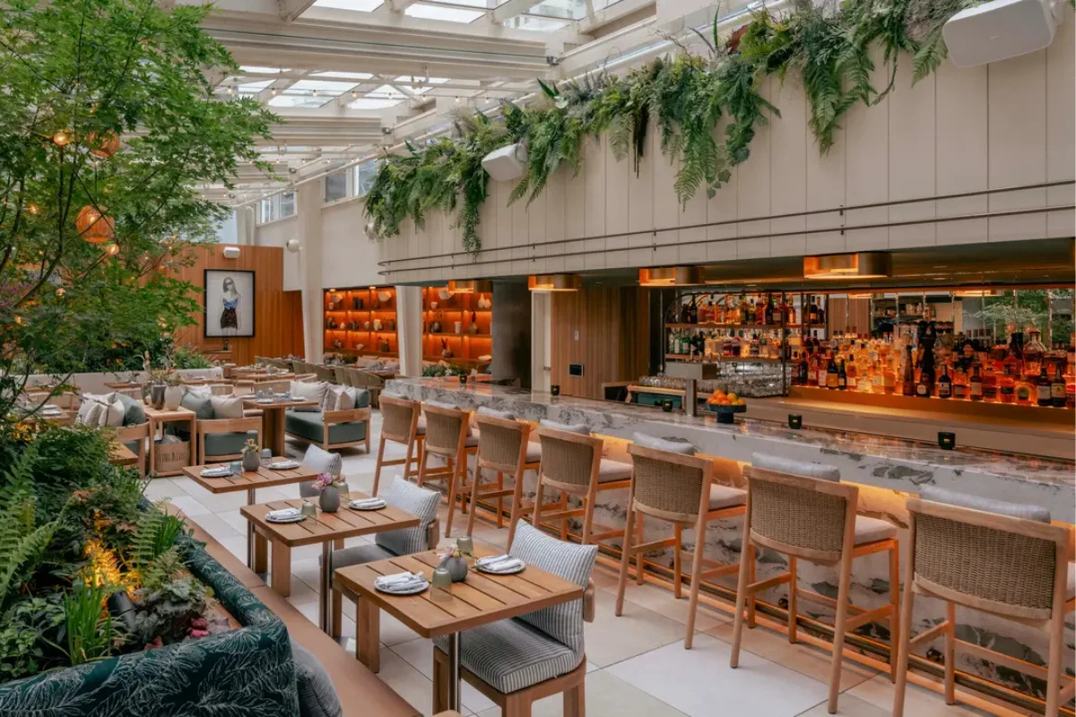 Upscale hotel restaurant interior with outdoor-inspired dining furniture, bar seating, and flexible hospitality seating