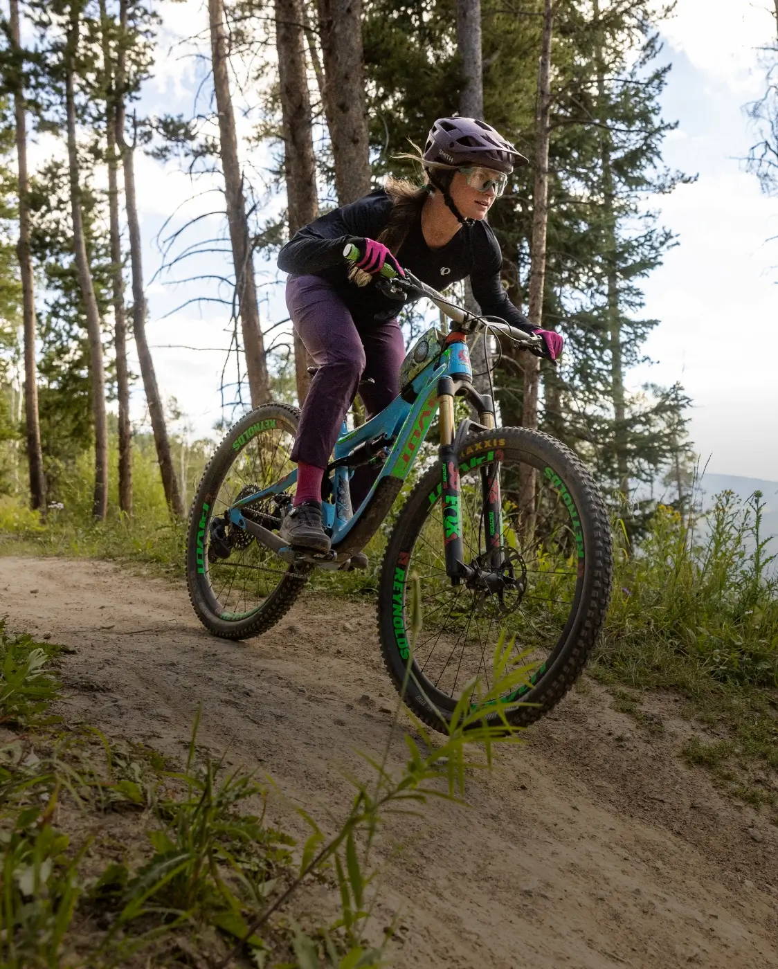 Female mountain biker riding down a trail wearing new PEARL iZUMi mountain bike apparel