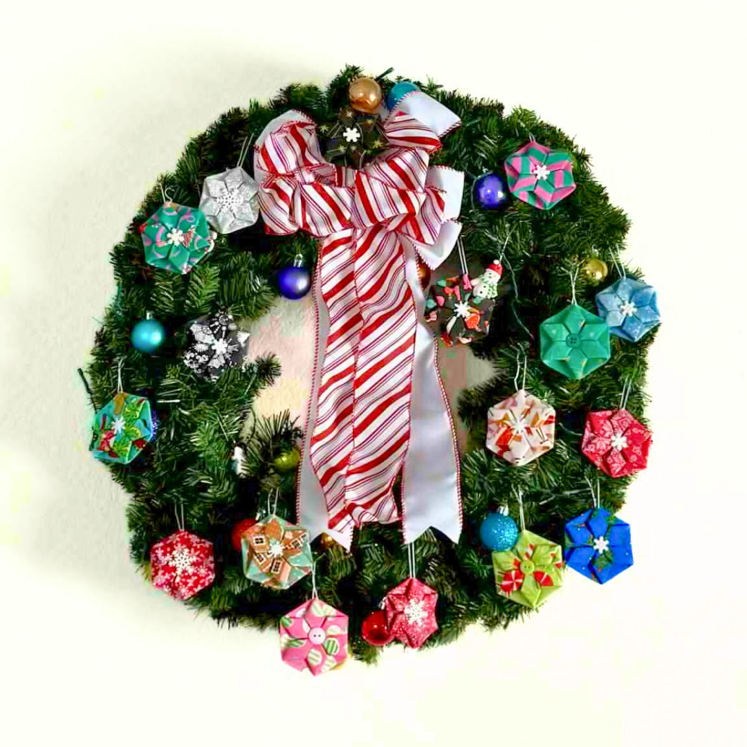 Colorful holiday wreath decorated with bows and ornaments.