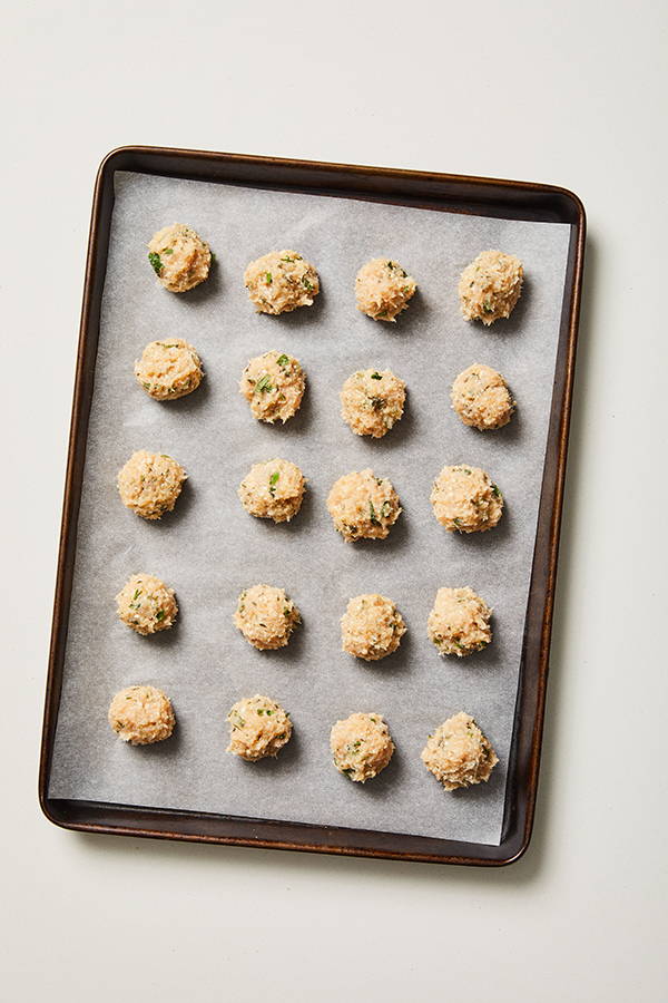 20 chicken meatballs on a parchment-lined baking sheet