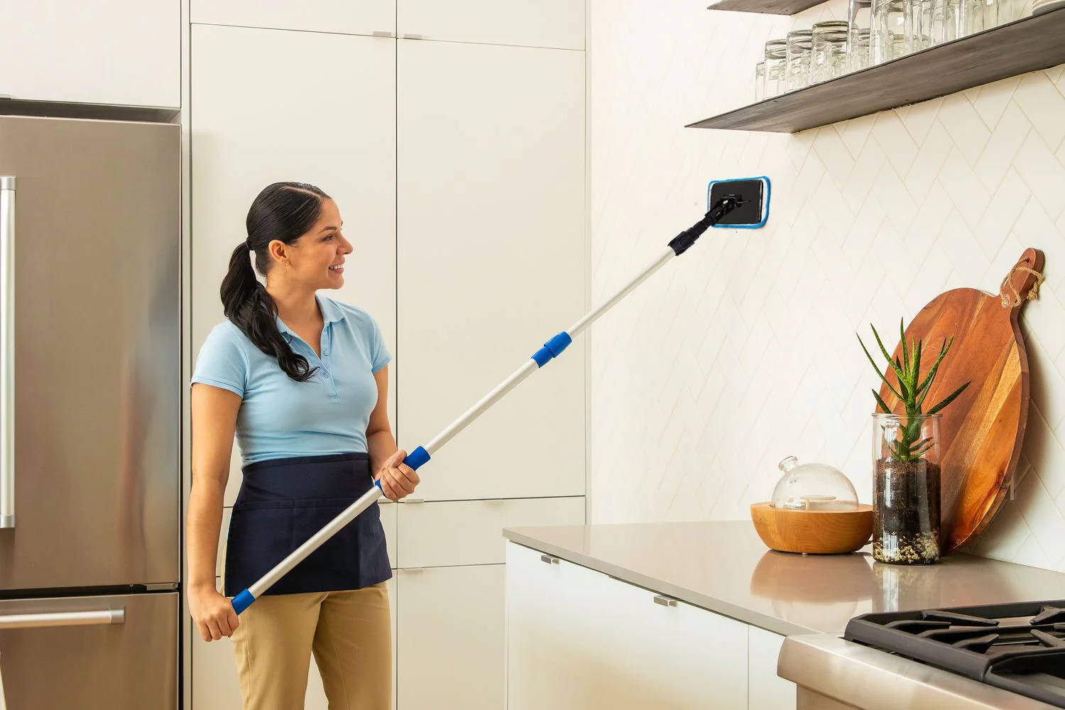 woman cleaning wall using Contour Frame mop
