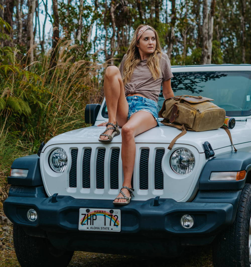 woman sitting on car in narrow sandals