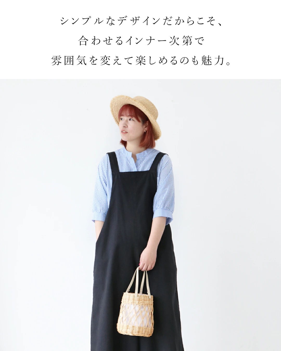 A woman in a hat and dress holds a bag, showcasing stylish simplicity.