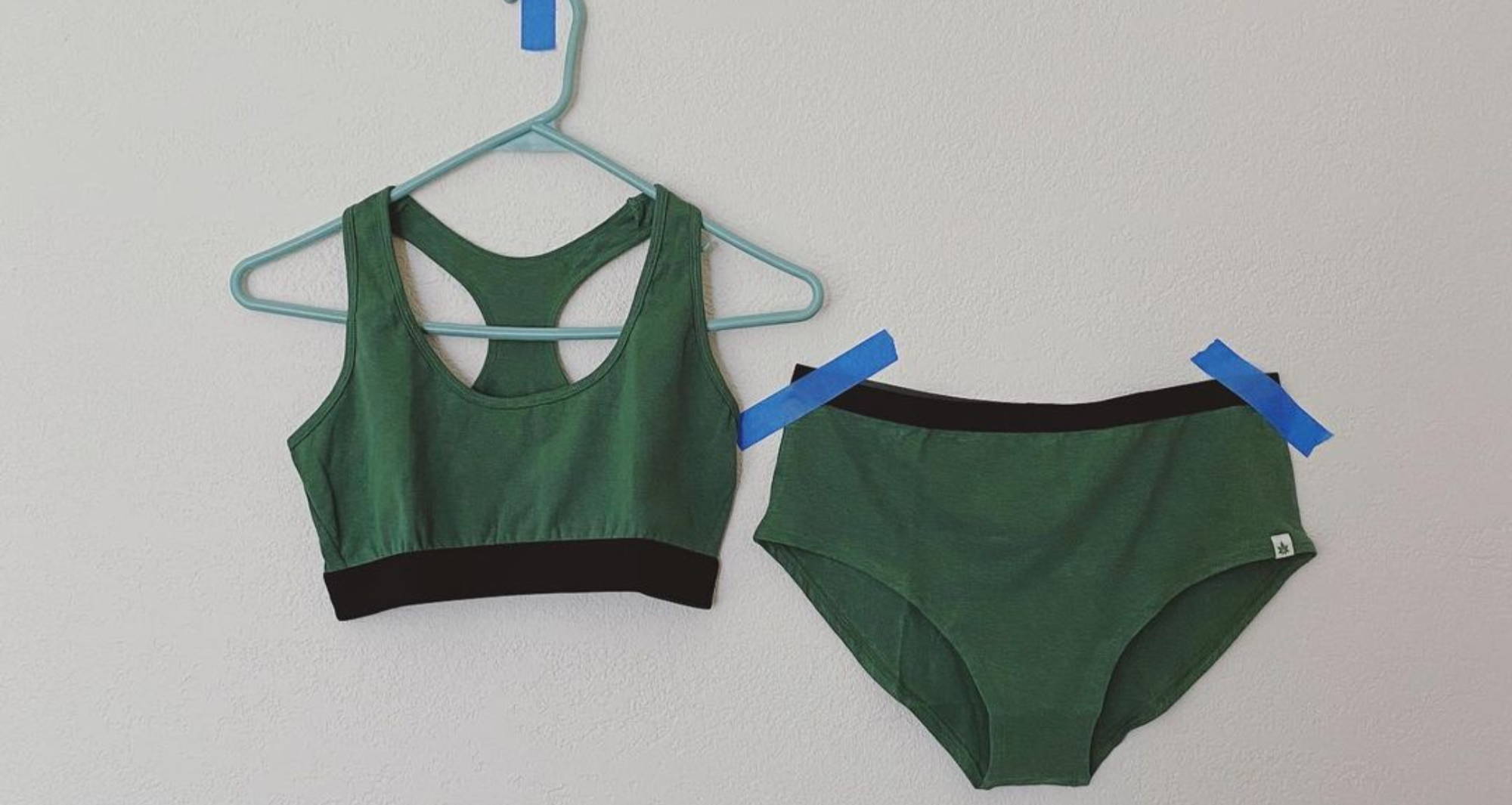 green bralette and underwear taped up with blue tape.